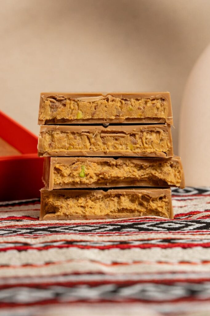 Close-up of an Abu Dhabi chocolate bar showing its layered filling of dates, tahina, saffron, and cardamom.